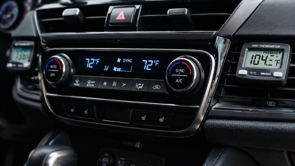 A digital dashboard display in an SUV showing dual-zone climate controls set to 72 degrees with a thermometer reading in the vent.